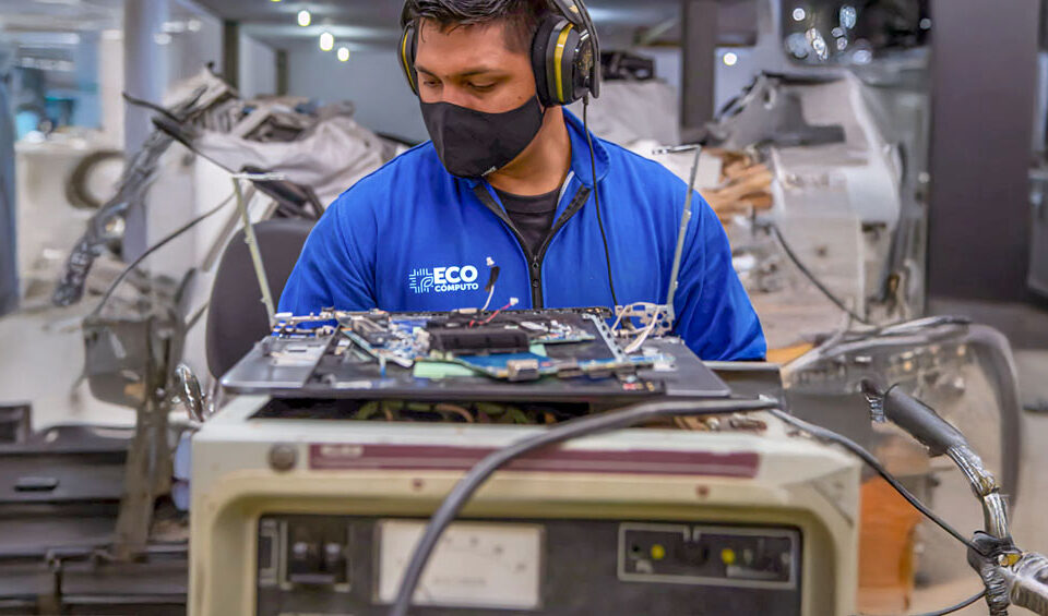 Operario de EcoCómputo desarmando un RAEE, ejemplo de la correcta gestión de Residuos de Aparatos Eléctricos y Electrónicos.